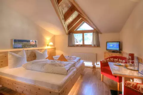 02_hotel-darrehof_doppelzimmer-bergblick-bett.webp